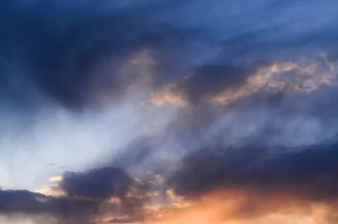 Cloud formation glowing above horizon during colorful sunset with dramatic Stock Photos