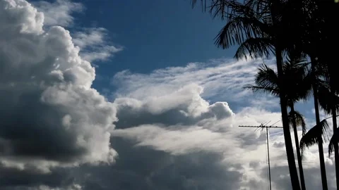 Cloud formation passing a house with TV aerial and trees in foreground. Видео 134663772