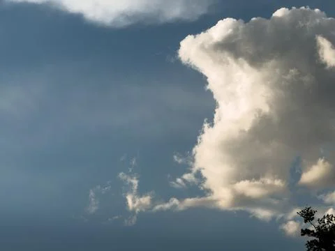 Cloud formation in the sky during the late afternoon near a tree line with .. Stock Photos