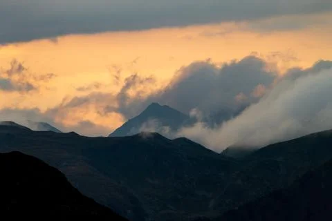 Cloud Formation Surrounds the Mountains at Sunset Stock Photos
