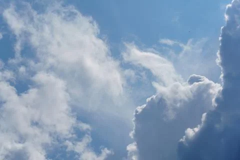 Cloud formations in a bright blue sky reveal patterns during a sunny afternoon Stock Photos