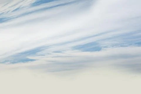Cloud formations floating across flat design sky, revealing pale blue gaps and Stock Photos