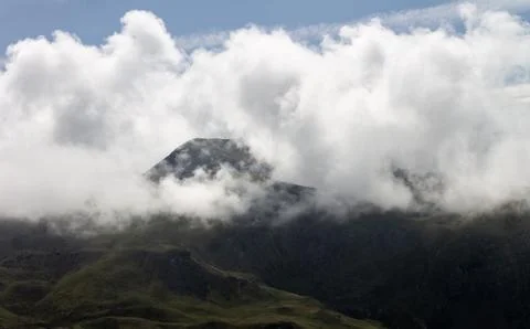 Cloud Formations surround Mountain Top Stock Photos