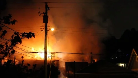 Cloud of glowing smoke lit by fire rises over houses in a Canadian neighborhood Stock Footage 93616662