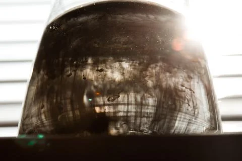 A cloud of ink in a transparent glass cup with clear water against the backdr Stock Photos
