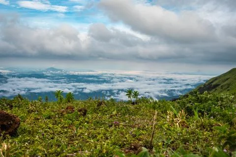 Cloud layers on mountain horizon with green grass Stock Photos