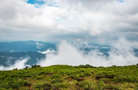 Cloud layers on mountain horizon with green grass 写真素材