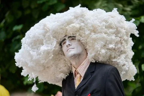 Cloud man performance with oversized fluffy headpiece in outdoor setting Stock Photos