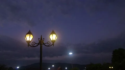 Cloud movement over the outdoor lamps in the evening Stock Footage 47732239