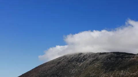 Cloud moving over mountain peak in dramatic sky landscape Stock Footage 330526930