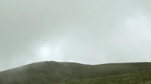 Cloud moving slowly above the greem mountain peak in cloudy day Stockbeeldmateriaal 90520999