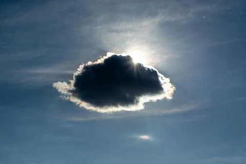 Cloud obscuring the sun in a blue sky Stock Photos