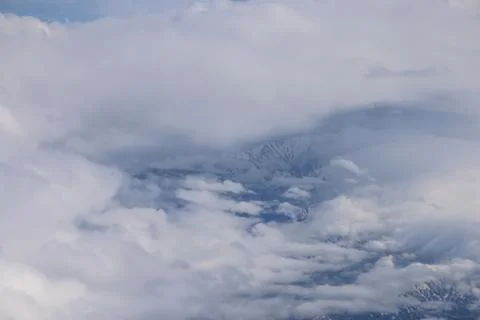 Cloud opening revealing mountain landscape below 스톡 사진