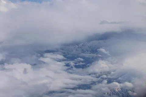 Cloud opening revealing mountain landscape below 스톡 사진