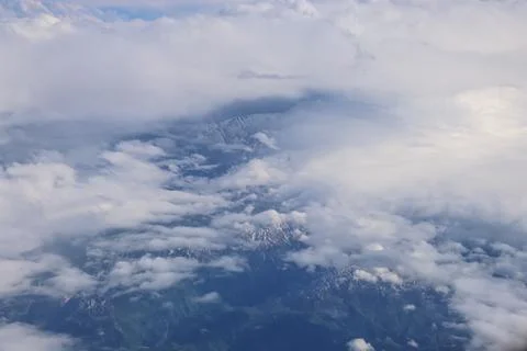 Cloud opening revealing mountain landscape below 스톡 사진