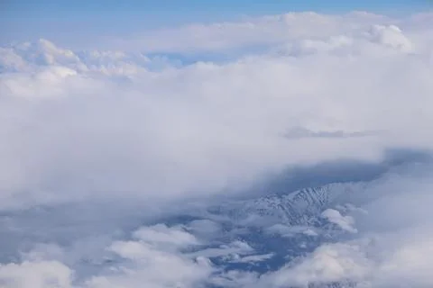 Cloud opening revealing mountain landscape below 스톡 사진