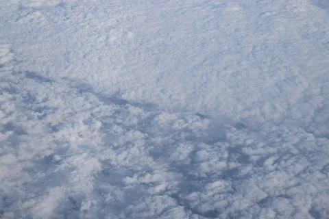Cloud opening revealing mountain landscape below 스톡 사진