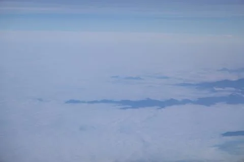 Cloud opening revealing mountain landscape below 스톡 사진
