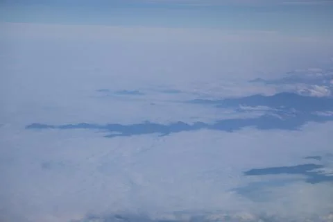 Cloud opening revealing mountain landscape below Foto stock