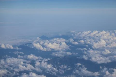 Cloud opening revealing mountain landscape below 스톡 사진