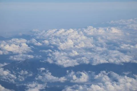 Cloud opening revealing mountain landscape below 스톡 사진