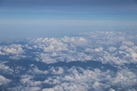 Cloud opening revealing mountain landscape below 스톡 사진