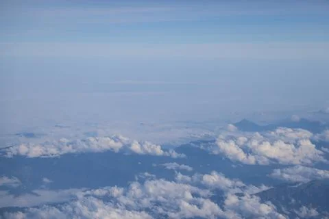 Cloud opening revealing mountain landscape below 스톡 사진