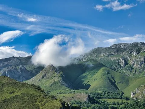 Cloud over green mountain range landscape - Majestic summer view of Picos d.. Stock Photos