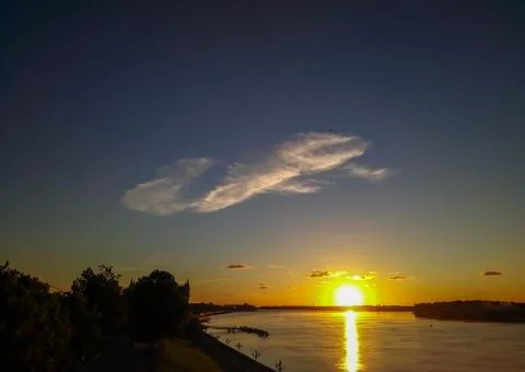 Cloud over the river in the rays of the sunset Stock Photos