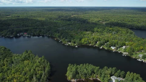 A cloud passes over a cottage dotted lake in rural Ontario Stock Footage 163330618