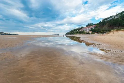 Cloud reflection in one of the pools left by the low tide on Mundaka beach Stock Photos