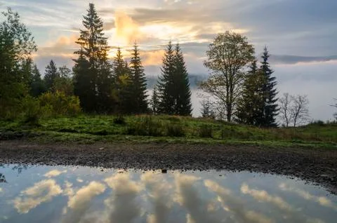 Cloud reflection in the puddles on the mountain road. 스톡 사진