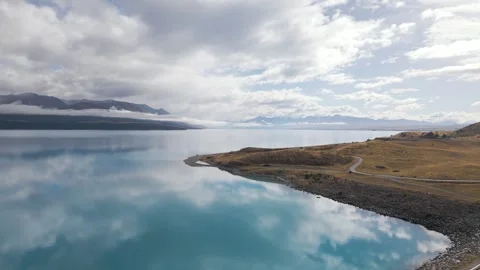 Cloud reflections in Lake Pukaki, New Zealand on calm day, aerial parallax Stock Footage 241768656