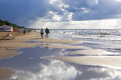 Cloud reflections at low tide on the ocean and a walk along the shore. Roma.. Stock Photos