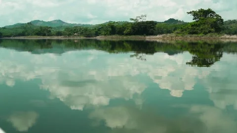 Cloud Reflections Mirror Across Glassy Water Surface Stock Footage 345452132