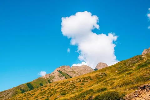 A cloud rises over the mountainside. cumulus cloud over the mountain Stock Photos