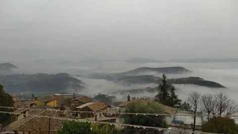Cloud sea moving under the roofs of an old Italian town Vídeo Stock 146223762