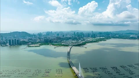 Cloud shadows across a bay and distant city bridge - Shenzhen Stock Footage 346615619