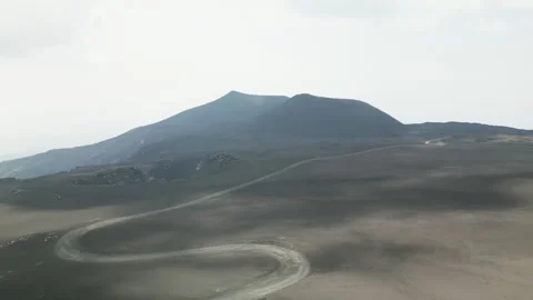 Cloud shadows create speckled pattern of light on barren black volcanic Stock Footage 277208764