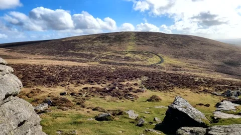 Cloud shadows pass over Grimspound dartmoor landscape Stock Footage 171022217