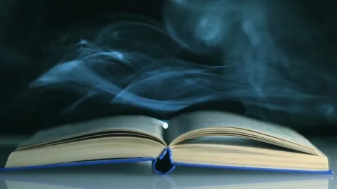 A cloud of smoke covers the pages of thick open bookм in a smoky space Stock Footage 313174478