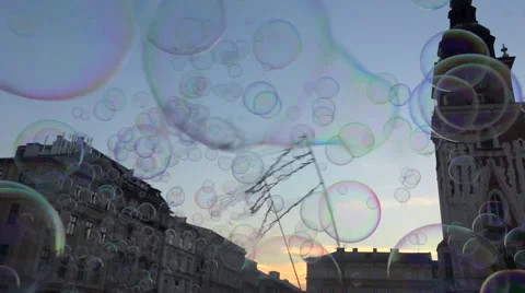 Cloud of soap bubbles on blue sky, public square with happy people - slow motion Stock Footage