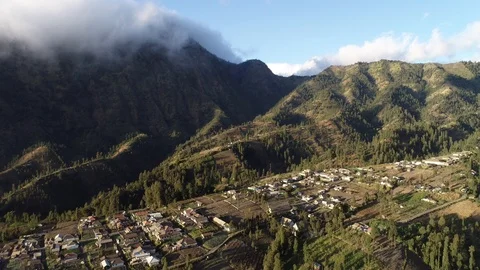 Cloud spilling over a ridge above a village in Probolinggo Stock Footage 95261426