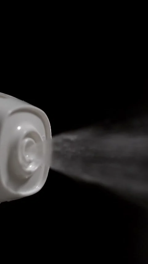 Cloud of spray from a white nozzle in a dark setting creating mist Stock Footage 323658191