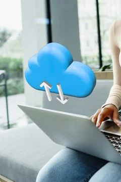 Cloud storage symbol appears above a person using a laptop at home during the 스톡 사진