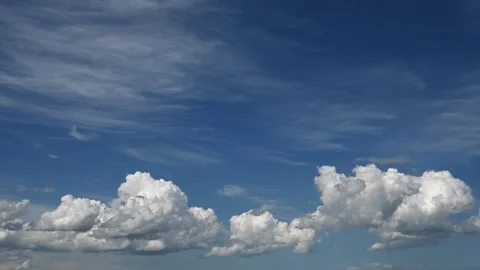 Cloud timelapse showing bright summer white clouds drifting across a vivid blue Stock Footage 329867953