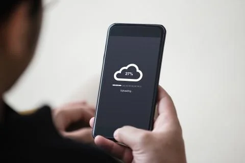 Cloud uploading concept on phone screen. Man hand hold phone doing cloud upload Stock Photos
