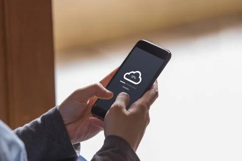 Cloud uploading concept on phone screen. Hands hold phone doing cloud uploading. Stock Photos