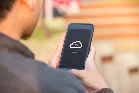 Cloud uploading concept on phone screen. Man hold phone doing cloud uploading  Stock Photos
