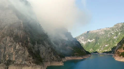 Cloud of white smoke lingering to the hillside, resembling fog or mist Stock Footage 159797147